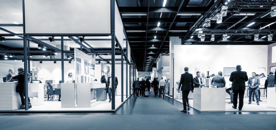 Visitors walking through exhibition booths at a trade show